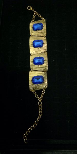 Pulseira em metal escovado dourado com pedra azul