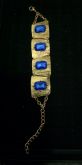 Pulseira em metal escovado dourado com pedra azul